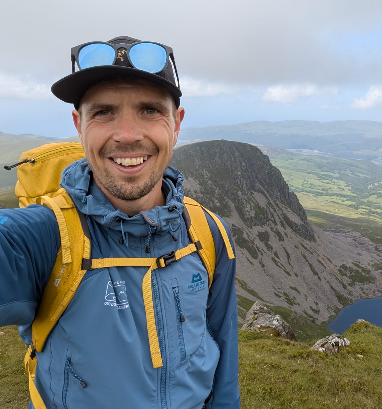 A photo of Brett Mahoney on a mountain in The Outdoor Partnership uniform